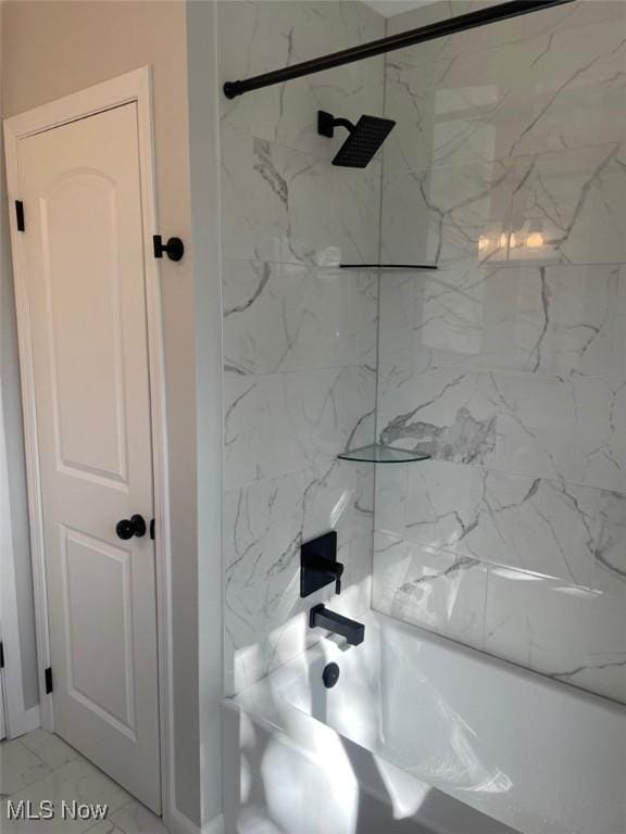 bathroom featuring marble finish floor and bathtub / shower combination