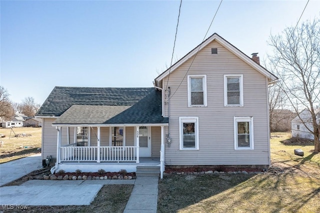 traditional home featuring roof with shingles, a porch, and a chimney