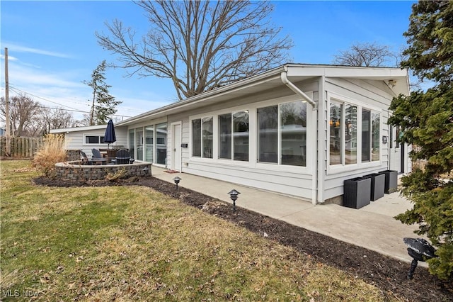 exterior space featuring fence, a lawn, a fire pit, and a patio