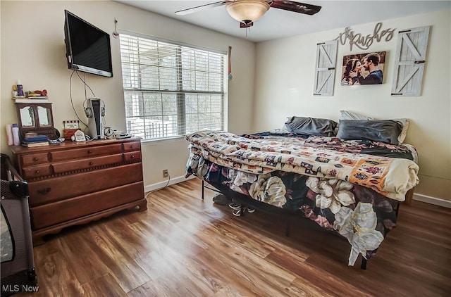 bedroom with a ceiling fan, baseboards, and wood finished floors