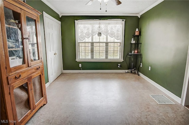 spare room with ornamental molding, visible vents, and baseboards