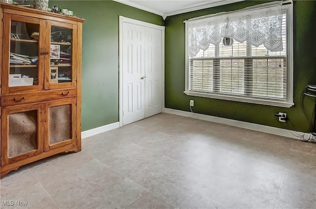 unfurnished bedroom featuring baseboards, a closet, and ornamental molding