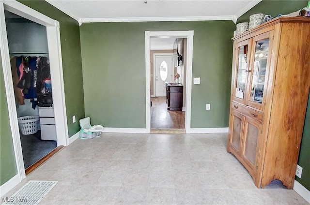 interior space featuring baseboards and crown molding