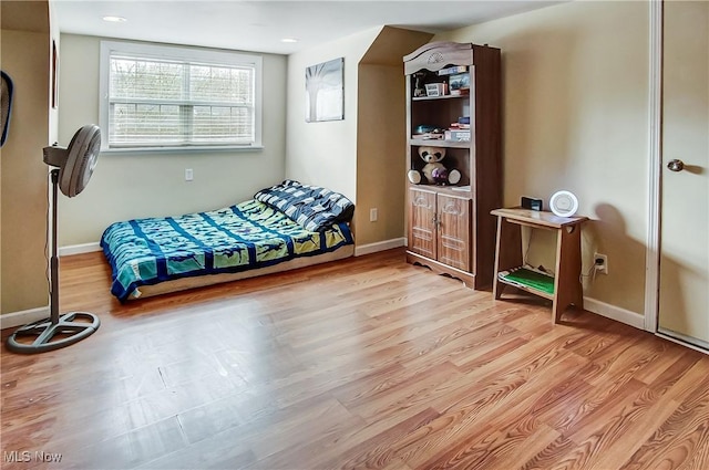 bedroom with baseboards and wood finished floors