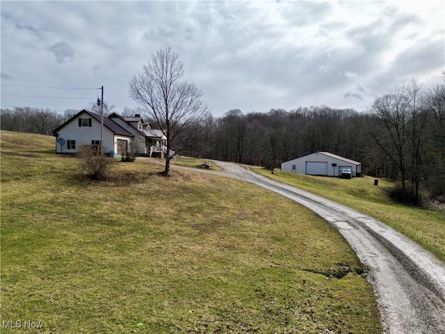 view of road with driveway and a view of trees