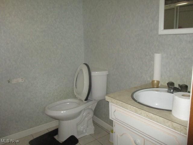 bathroom featuring wallpapered walls, baseboards, toilet, tile patterned floors, and vanity