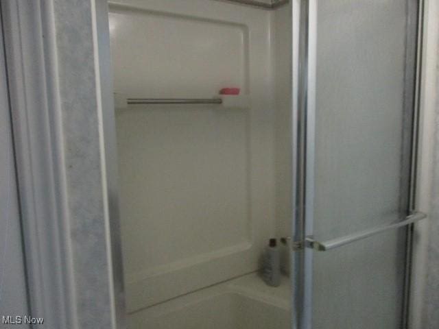 full bathroom featuring a shower with door and a bathtub