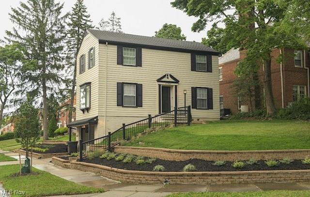 colonial-style house featuring a front lawn