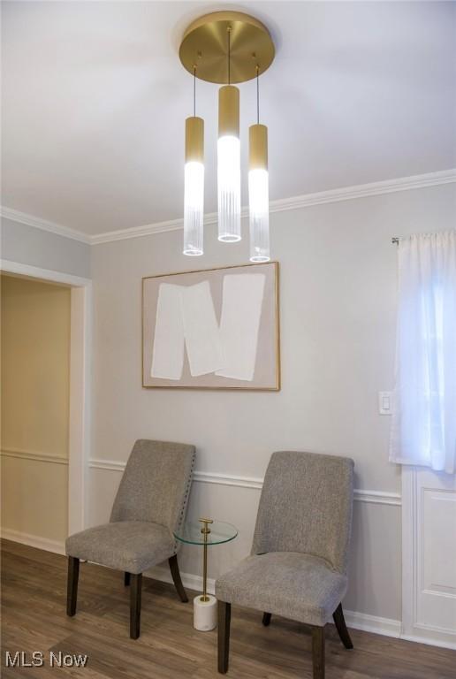 sitting room featuring baseboards, ornamental molding, and wood finished floors