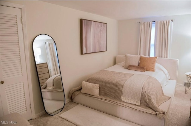 bedroom with baseboards and light colored carpet