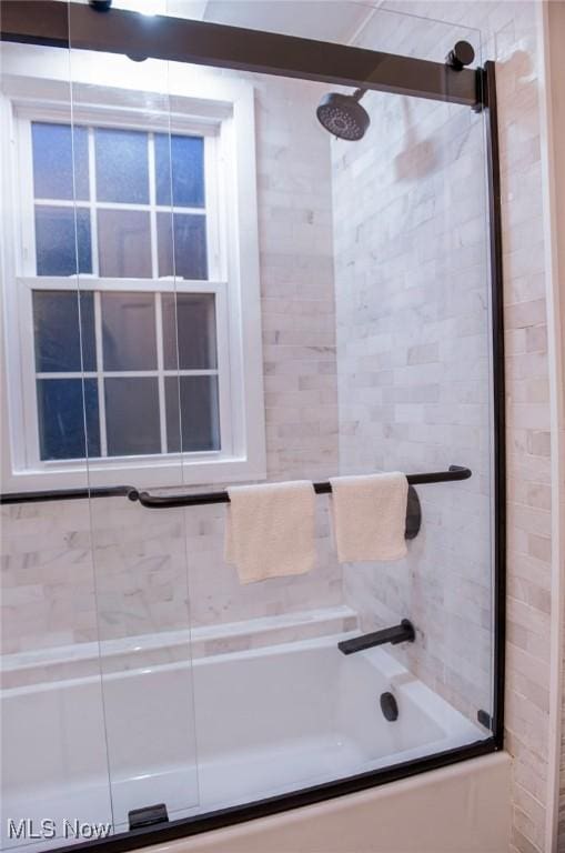 bathroom featuring combined bath / shower with glass door