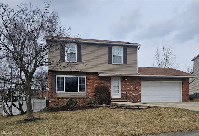 colonial house featuring brick siding, fence, concrete driveway, a front yard, and a garage