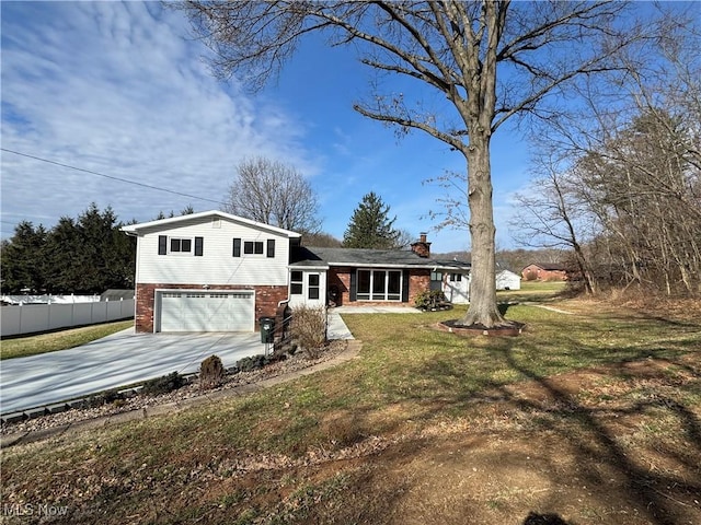 split level home with a garage, brick siding, fence, driveway, and a front yard