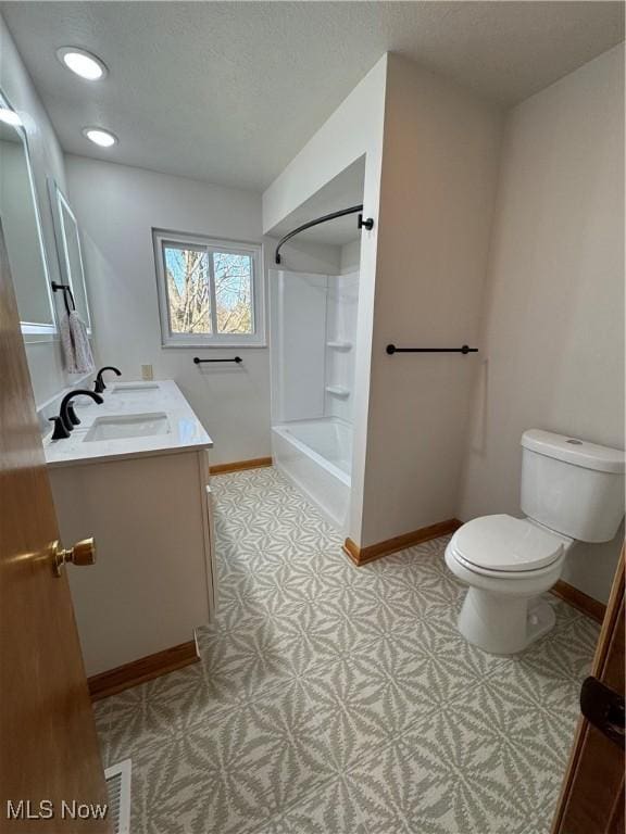 full bathroom with toilet, baseboards, shower / washtub combination, and vanity