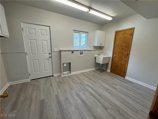 laundry area with cabinet space, hookup for a washing machine, light wood-style floors, and electric dryer hookup