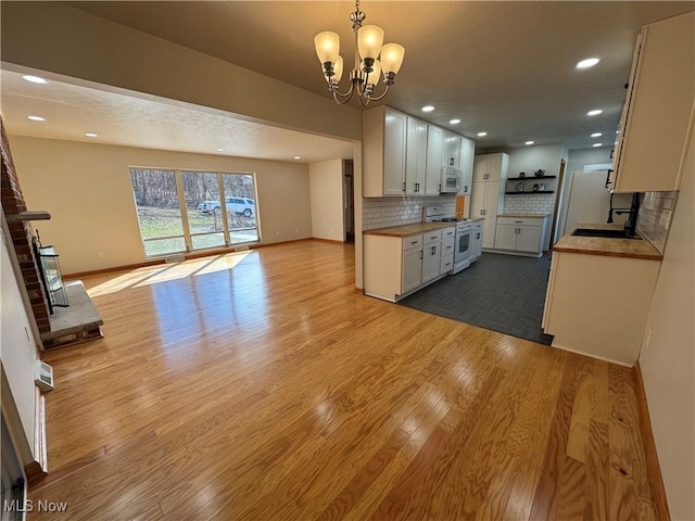 kitchen featuring white cabinets, white appliances, open floor plan, and dark wood-type flooring