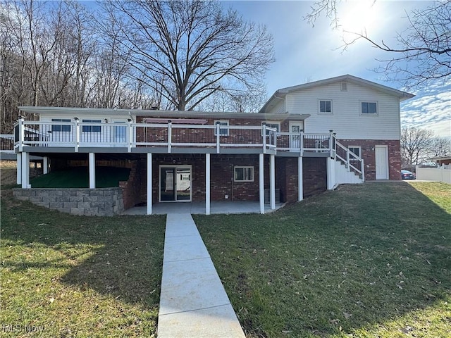 view of front of home featuring a deck, brick siding, a front yard, stairway, and a patio area