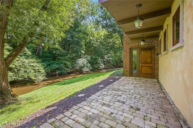 entrance to property featuring brick siding and a patio area