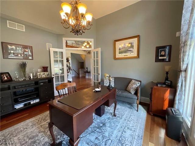 office space with french doors, visible vents, a notable chandelier, and wood finished floors