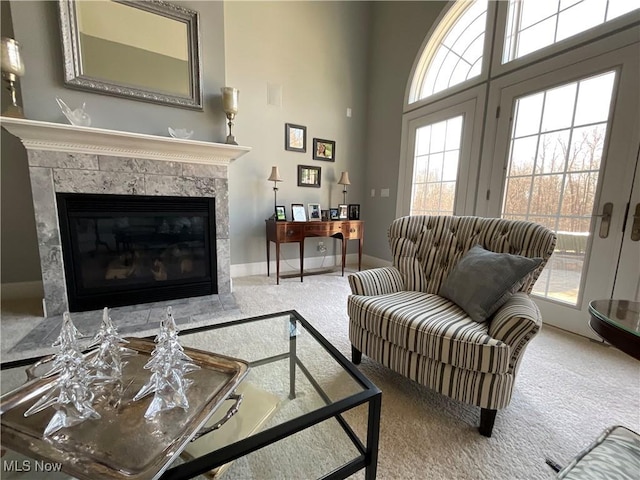 carpeted living room featuring french doors, a fireplace, and baseboards