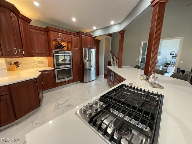 kitchen with stainless steel appliances, marble finish floor, light countertops, tasteful backsplash, and decorative columns