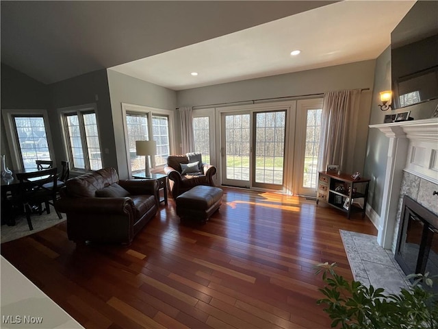 living room with baseboards, a tile fireplace, hardwood / wood-style flooring, and recessed lighting