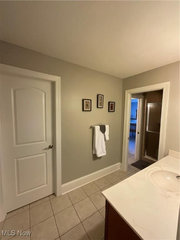 bathroom featuring vanity, baseboards, and tile patterned floors