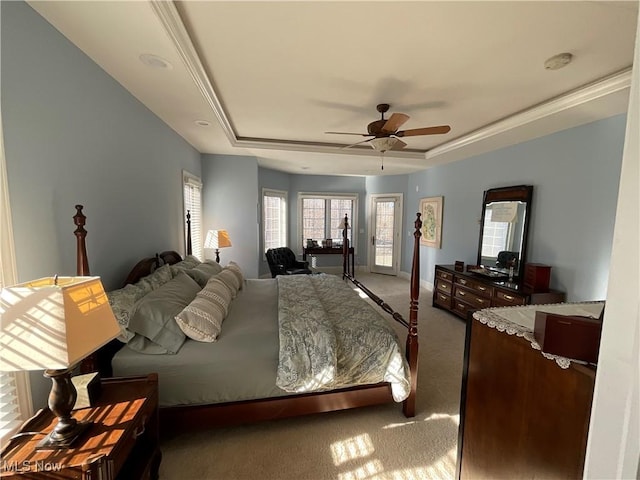 carpeted bedroom with ceiling fan, baseboards, a raised ceiling, and access to exterior