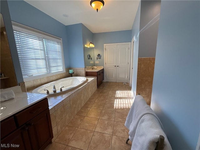 full bathroom featuring tile patterned flooring, a bath, and vanity