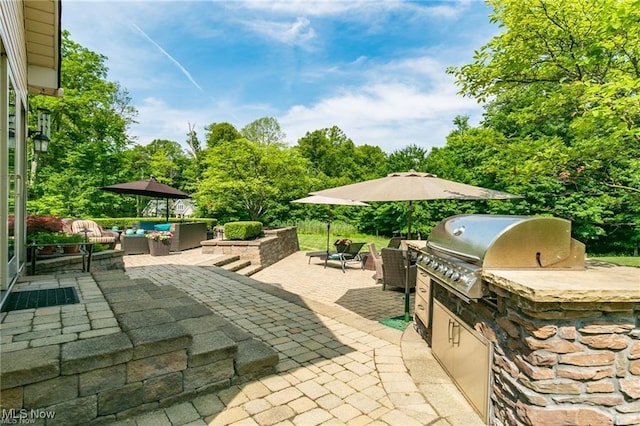 view of patio with exterior kitchen, outdoor lounge area, and grilling area