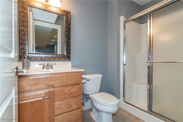 bathroom featuring vanity, a shower stall, toilet, and tile patterned floors