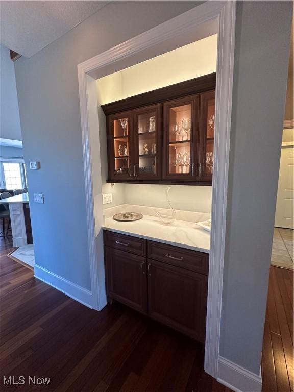 bar featuring dark wood finished floors and baseboards