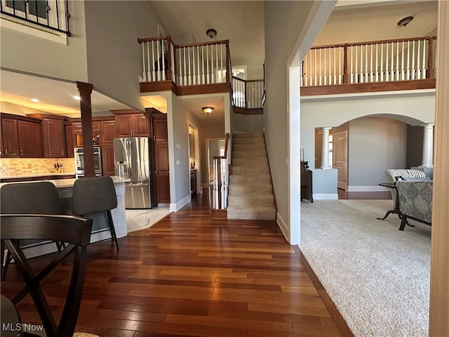 interior space featuring dark wood-style floors, arched walkways, and ornate columns