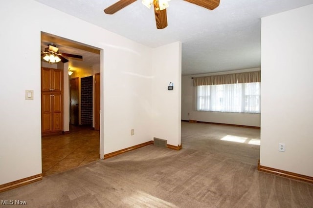 spare room with carpet, baseboards, ceiling fan, and tile patterned flooring