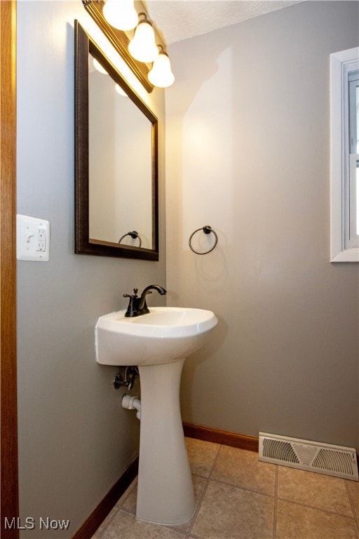 bathroom featuring tile patterned flooring, visible vents, and baseboards