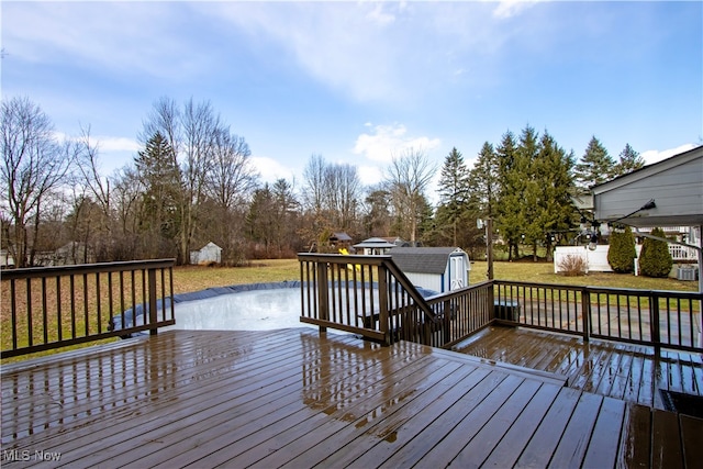 deck featuring an outbuilding, a lawn, and a shed