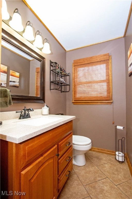 bathroom with toilet, tile patterned flooring, baseboards, and vanity