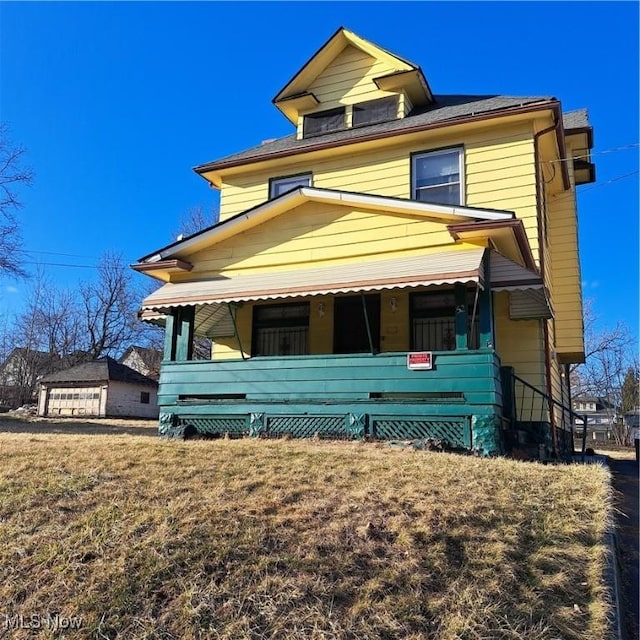 american foursquare style home featuring covered porch and a front yard