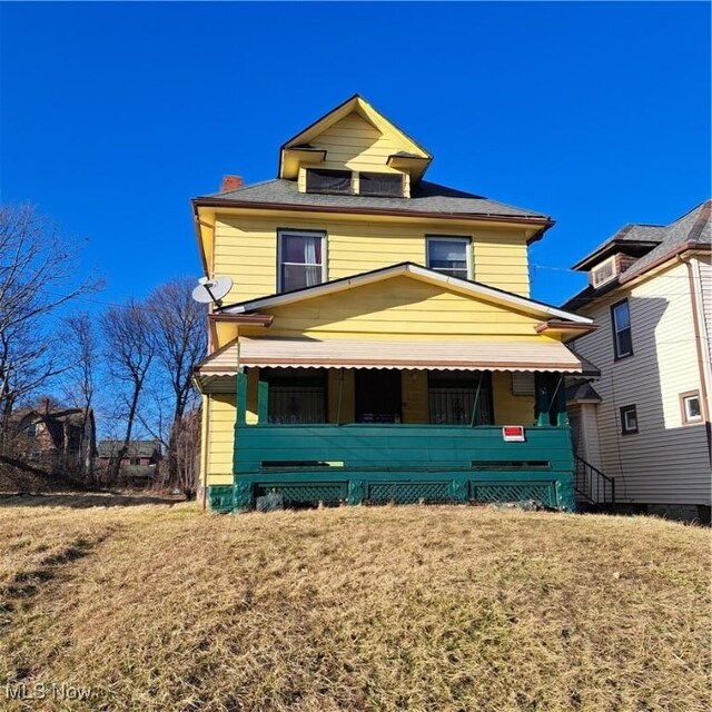 traditional style home featuring a porch and a front yard