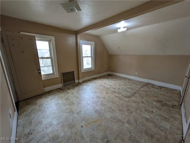 additional living space featuring vaulted ceiling and baseboards