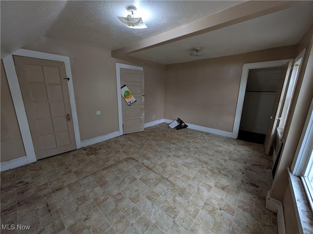 interior space with baseboards and a textured ceiling