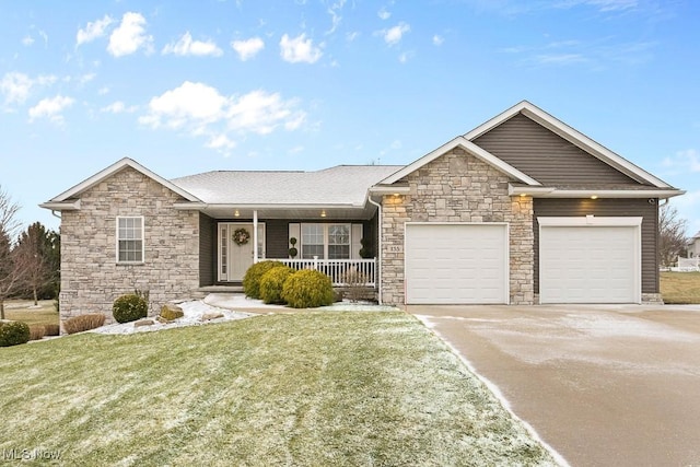 ranch-style home featuring a garage, covered porch, concrete driveway, and a front yard