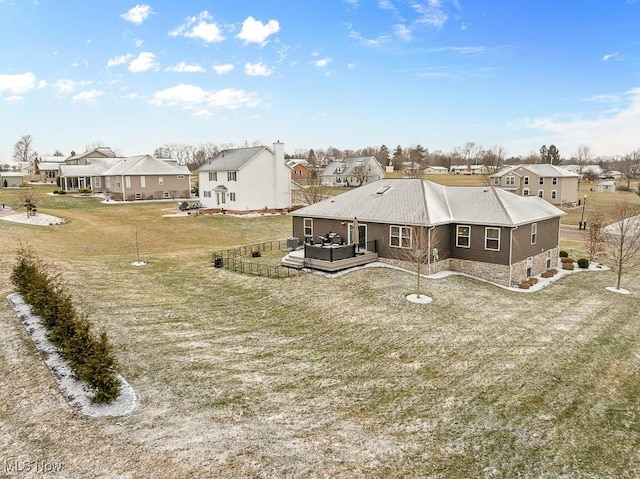 back of house featuring outdoor lounge area, a residential view, a deck, and a yard