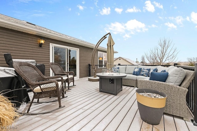 wooden terrace with area for grilling and an outdoor living space with a fire pit