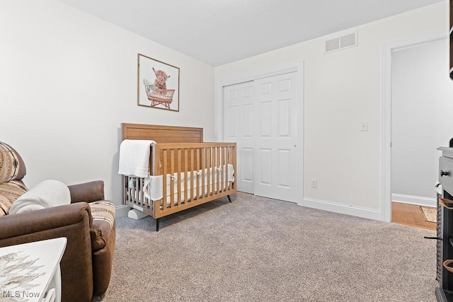 bedroom with carpet, a closet, visible vents, and baseboards