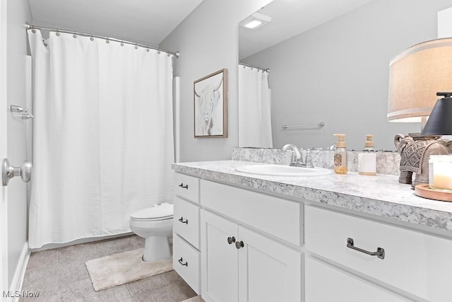 bathroom with curtained shower, vanity, and toilet