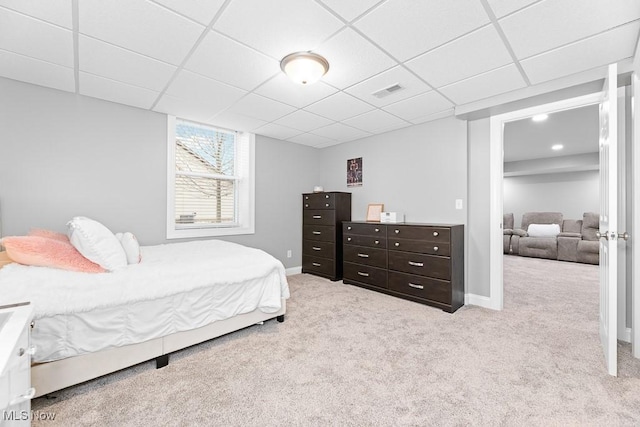 carpeted bedroom featuring a drop ceiling, visible vents, and baseboards