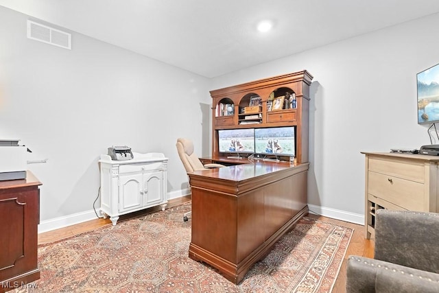 office space featuring baseboards, visible vents, and light wood-style floors