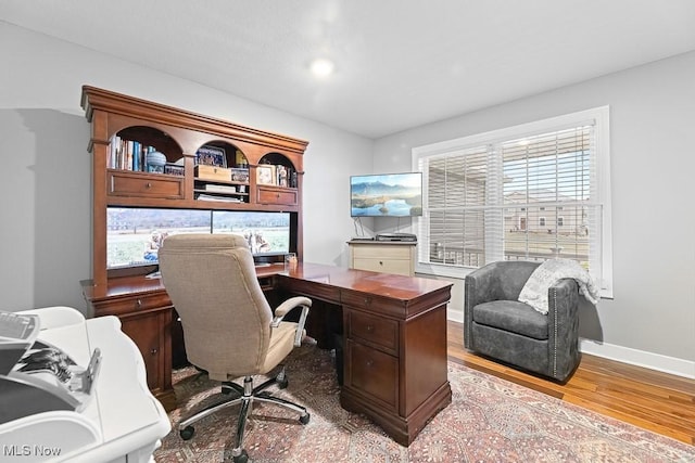 office area featuring baseboards and wood finished floors