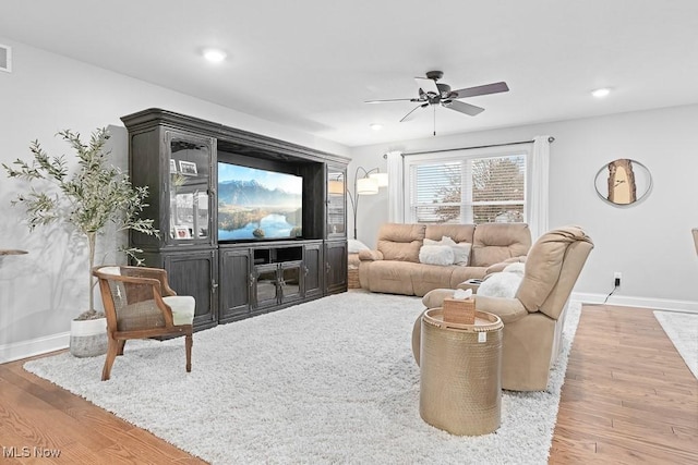 living area featuring recessed lighting, wood finished floors, a ceiling fan, and baseboards